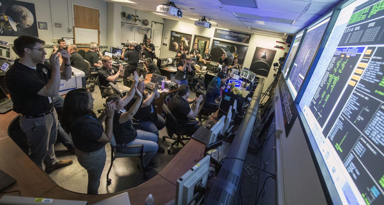 Feest bij de NASA nadat New Horizons contact maakt met de aarde.