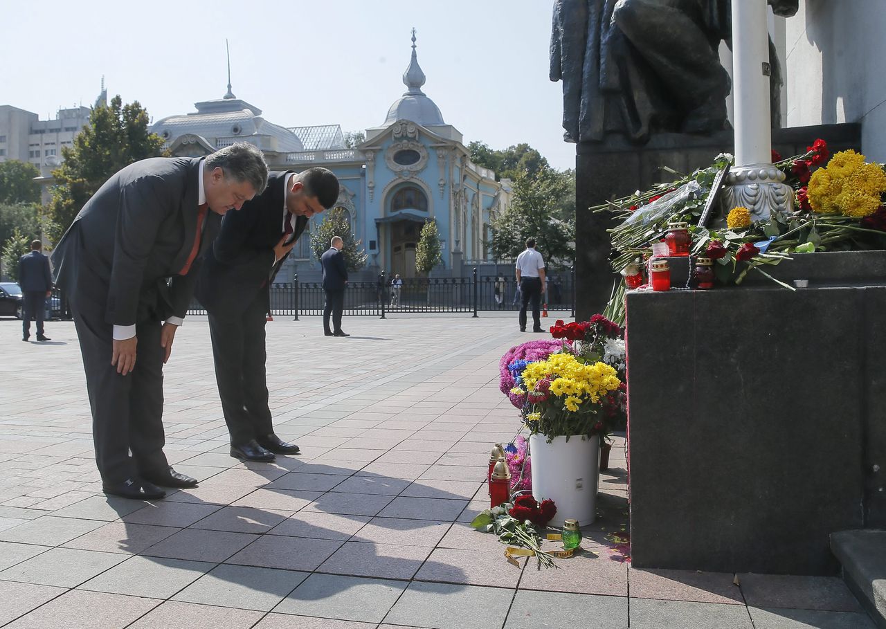 De Oekraïense president Petro Porosjenko legt bloemen neer voor de soldaten die maandag omkwamen.