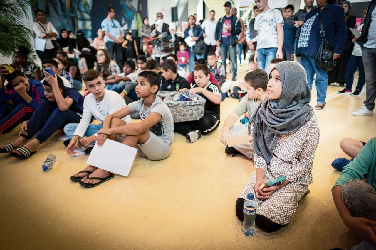 Mariam (grijze hoofddoek) is een van de duizend Haagse scholieren die een smartphone krijgen. De actie is bedoeld om ‘digitaal isolement’ tegen te gaan.