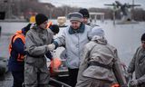 Rescue workers help a woman down during an evacuation in Orsk, Russia, due to rising water levels. 