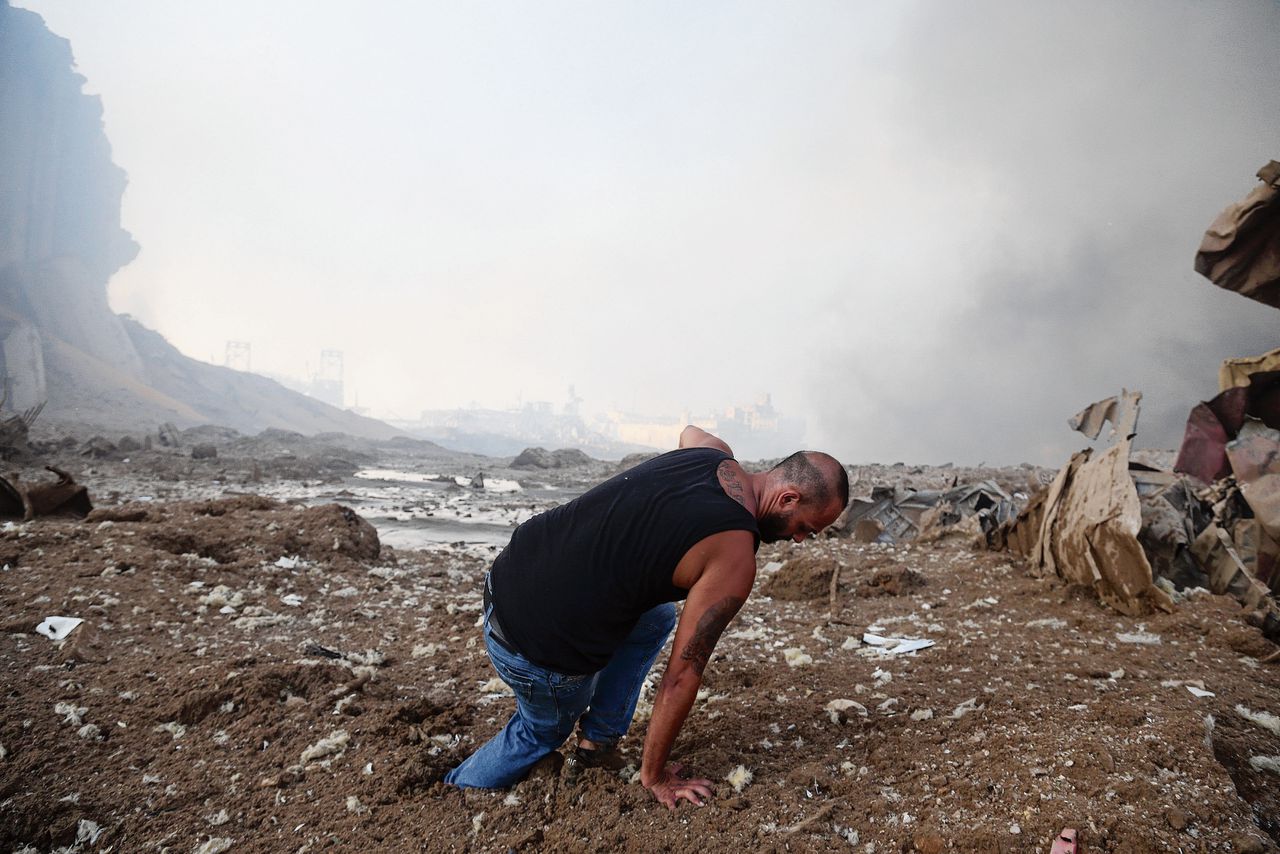 Een man loopt door de modder, woensdag in het verwoeste gebied rond de haven van de Libanese hoofdstad Beiroet.
