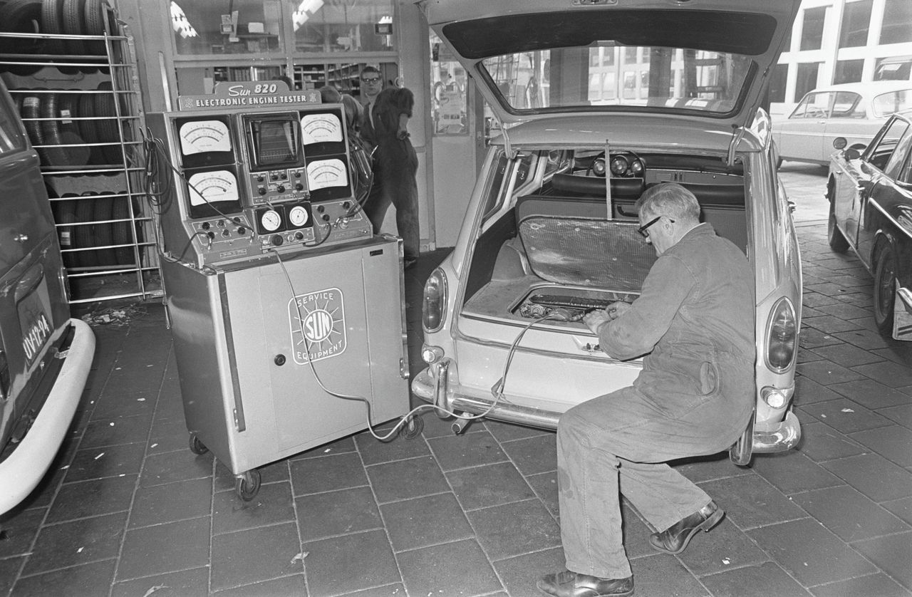 Een automonteur maakt gebruik van nieuwe technologie in 1968.