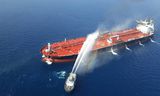Een blusboot van de Iraanse marine probeert een brand te blussen die ontstond na een explosie op de Noorse tanker Fort Altair, donderdag. De foto is verspreid door het Iraanse persagentschap Tasnim.