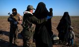 Een vrouw wordt gefouilleerd bij de evacuatie van het laatste IS-bolwerk in Baghouz, in Syrië.