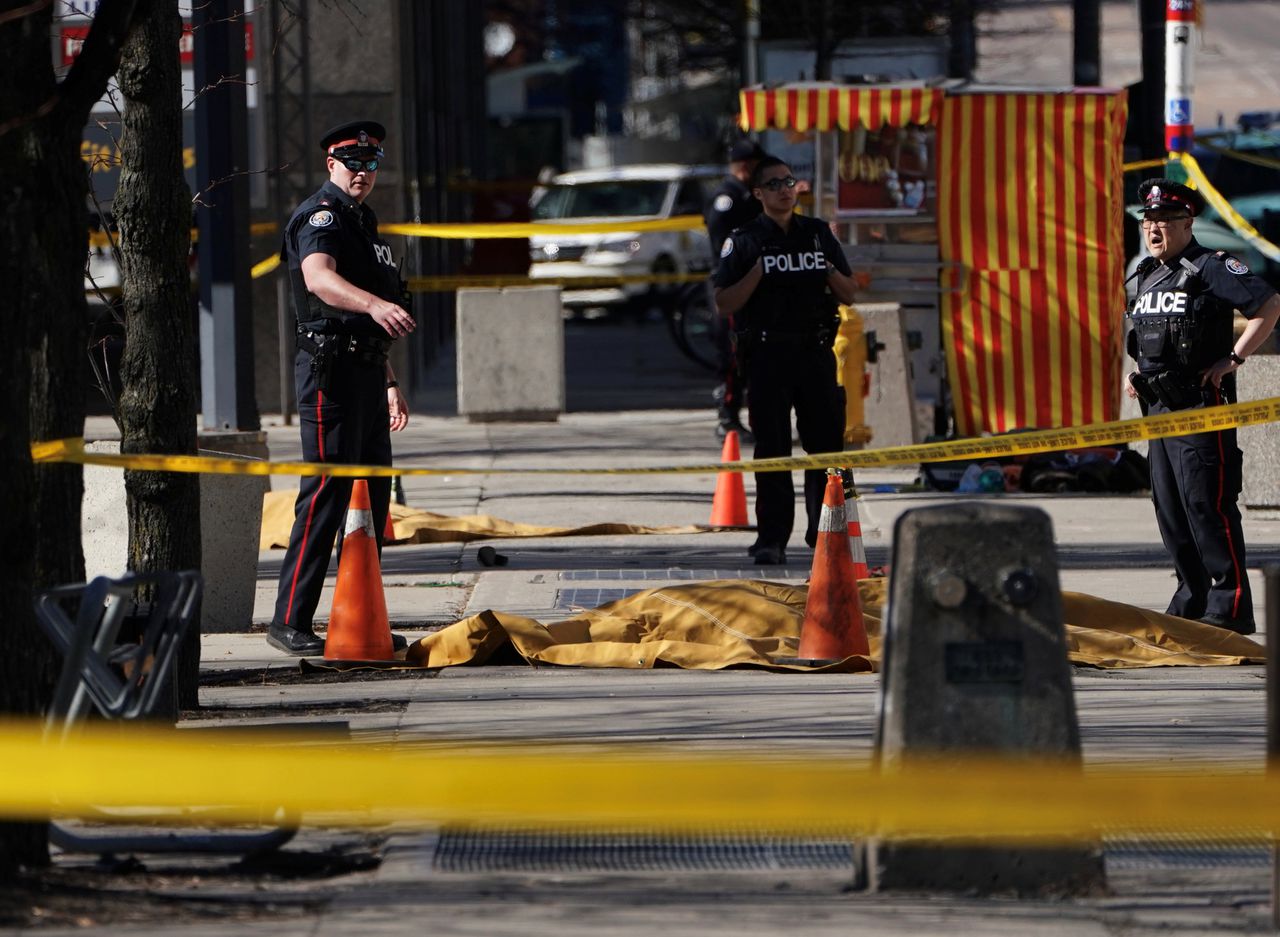 Politieagenten staan bij bedekte lichamen van slachtoffers, nadat een bestelbusje maandag inreed op voetgangers in de Canadese stad Toronto.
