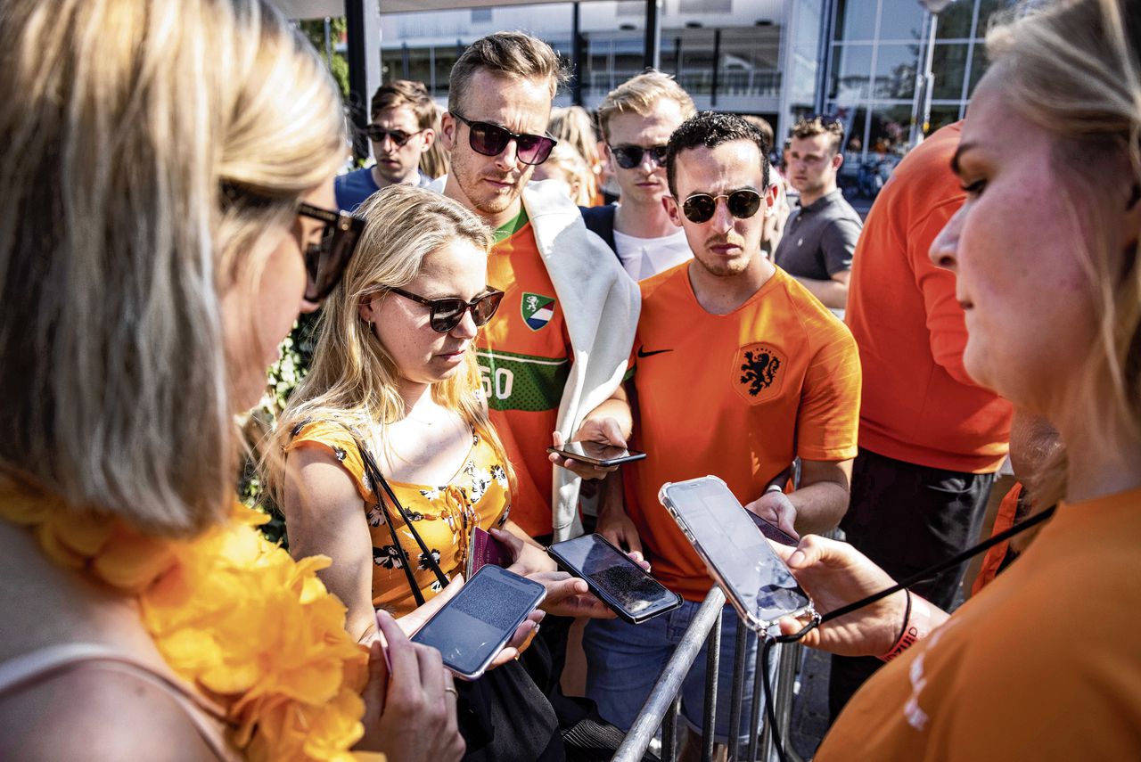 Voetbalfans laten een testbewijs zien om op een terras de EK-wedstrijd Nederland-Tsjechië te kunnen bekijken.