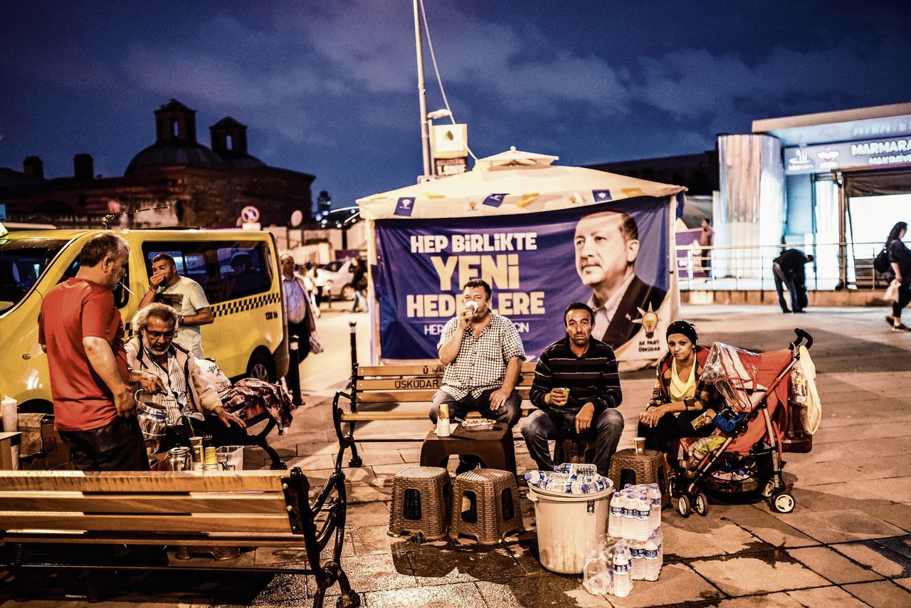 Bewoners van de Istanbulse wijk Uskudar voor een banier met de tekst ‘Samen op weg naar nieuwe doelen’, 28 mei 2018