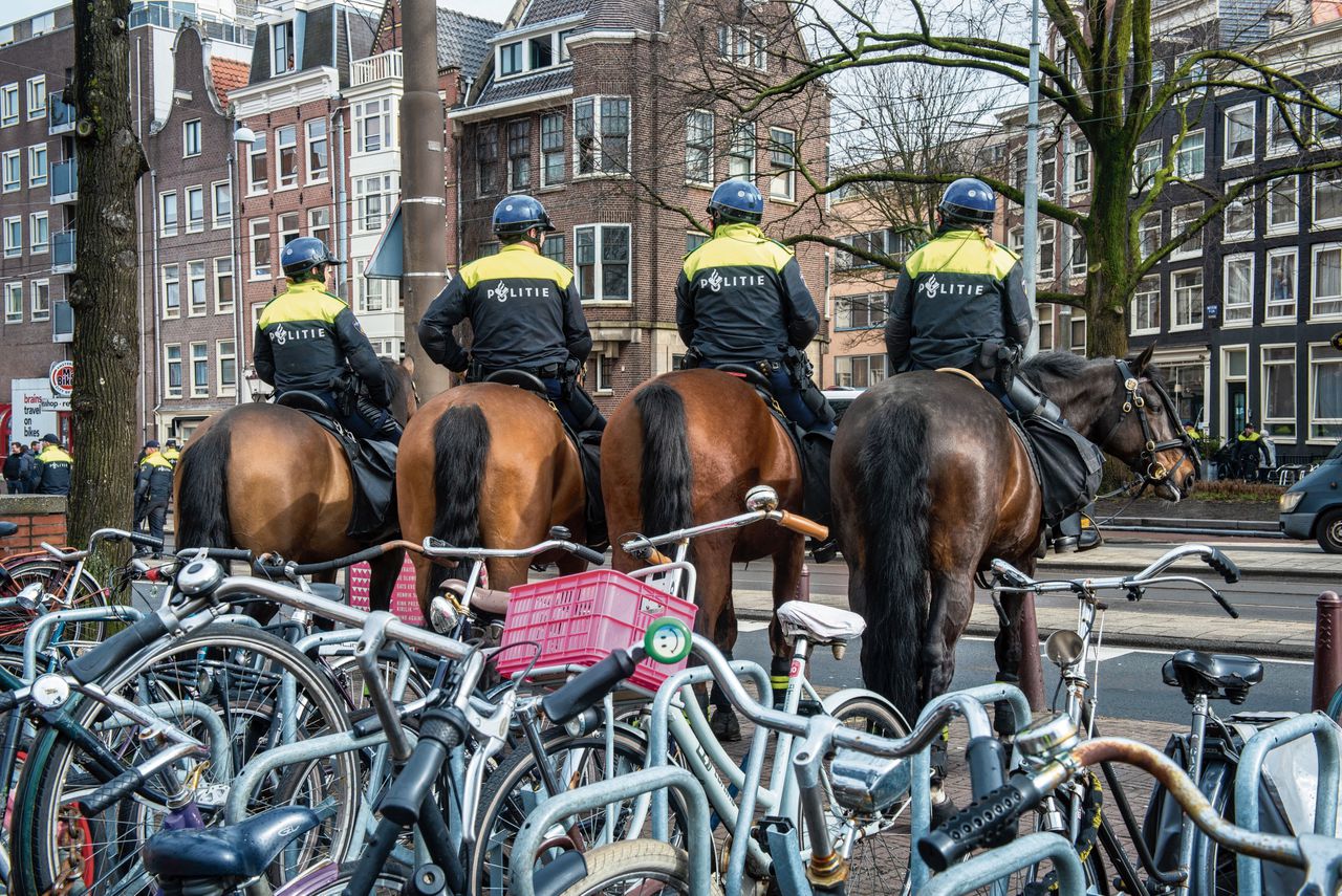 Politie te paard staat klaar om bij calamiteiten uit te rukken tijdens een demonstratie van Pegida in Amsterdam.
