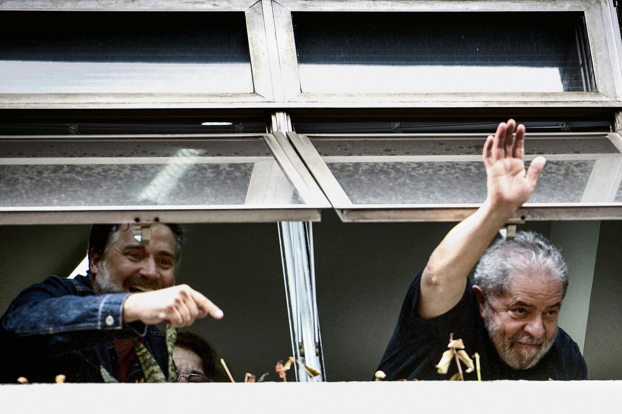 De vroegere Braziliaanse president Lula da Silva (rechts) wuift naar aanhangers, nadat hij weer door de politie is vrijgelaten.