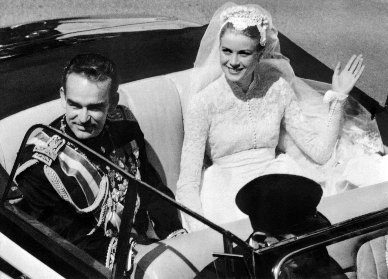 TO GO WITH AFP STORY BY CATHERINE MARCIANO (FILES) Prince Rainier III of Monaco and US actress and princess of Monaco Grace Kelly salute the crowd as they leave Saint Nicholas Cathedral after their wedding ceremony in Monaco on April 19, 1956 in a convertible cream and black Rolls Royce offered by the people of Monaco as a wedding gift. Prince Albert and his South African fiancee Charlene Wittstock, an Olympic swimming star, will celebrate their wedding over two days on July 2 and 3. In Monaco, commentators are convinced that the marriage of Prince Albert will be an even bigger event than his parents' 1956 wedding, which saw prince Rainier tie the knot with US film star Grace Kelly. AFP PHOTO