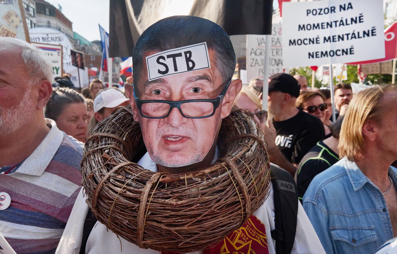 Een man met een foto van premier Babis bij een groot protest in Praag.