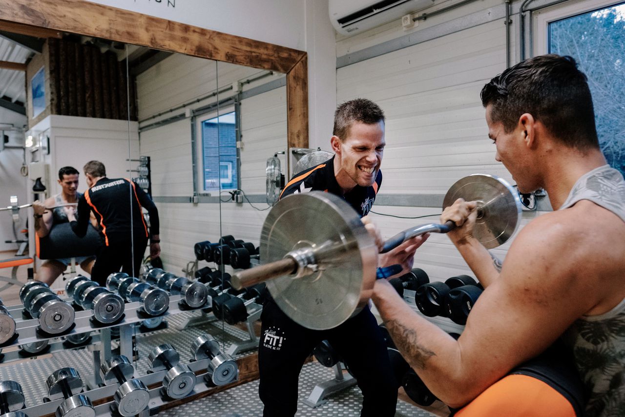 Jeroen Zuidema assisteert een sporter bij gewichtheffen in zijn Apeldoornse sportschool.