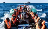 Migranten die werden gered op een opblaasbare boot ergens tussen Malta en Tunesië. 