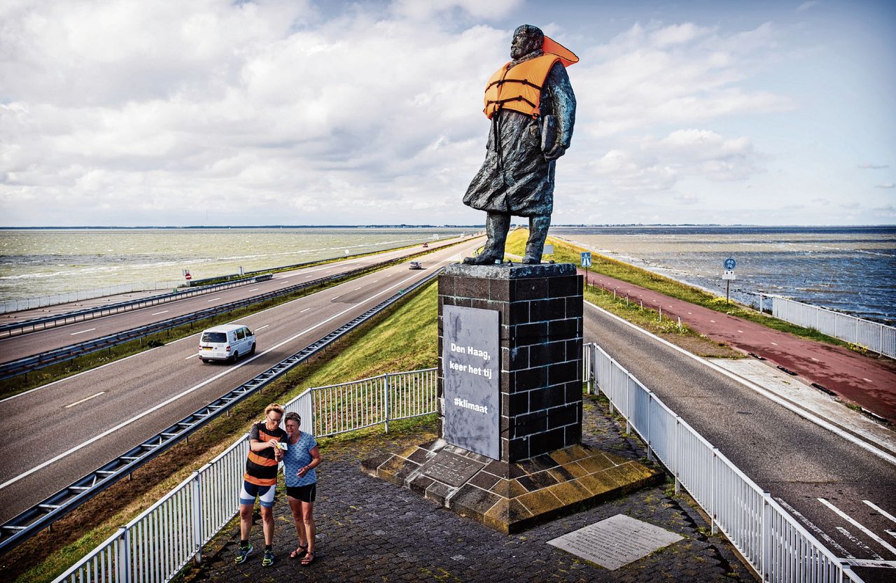 Greenpeace heeft het standbeeld van ingenieur Cornelis Lely op de Afsluitdijk in een oranje zwemvest gehuld. Op een bord staat ‘Den Haag, keer het tij’.