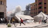 Palestijnen zoeken dekking na een Israëlische aanval op een gebouw in Jabalia in het noorden van de Gazastrook. Foto Bashar Taleb/AFP 