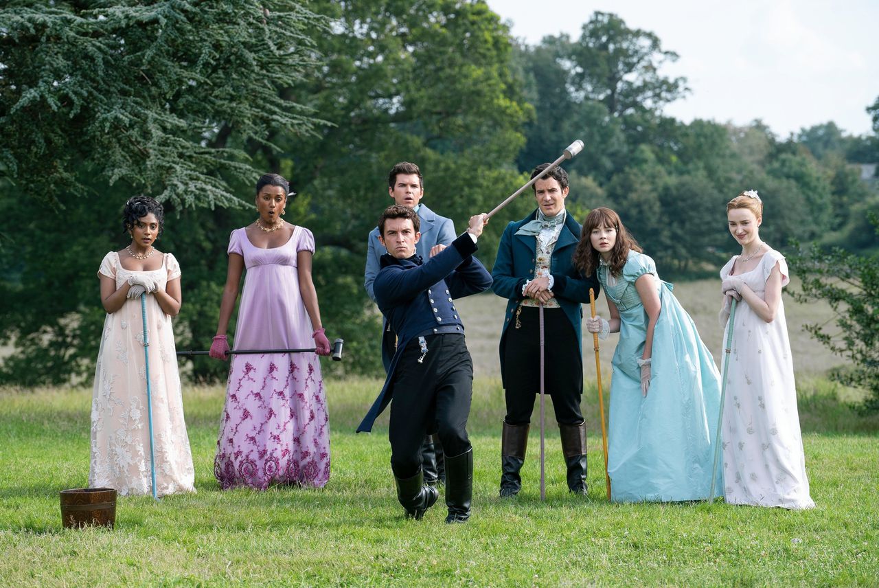 De Bridgertons spelen het balspel malie, een voorloper van croquet. Uiterst rechts: Phoebe Dyvenor als Daphne Bridgerton, daarnaast haar feministische zusje Eloise (Claudia Jessie).