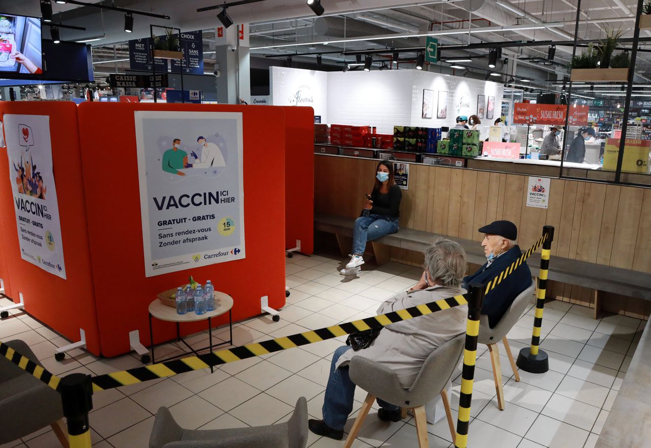 Belgen wachten eind augustus om gevaccineerd te worden bij een inentingscentrum in een supermarkt.