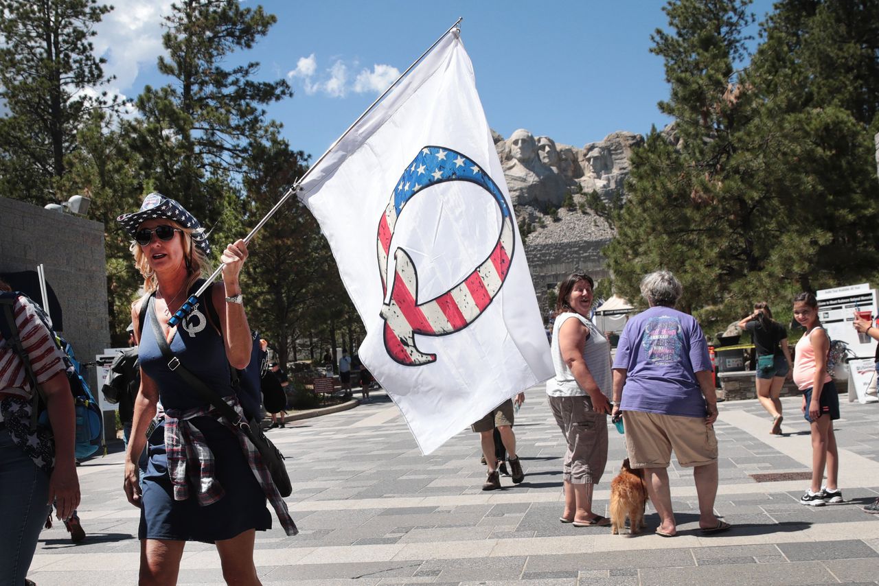 Een Donald Trump-supporter met een vlag van de QAnon-beweging.