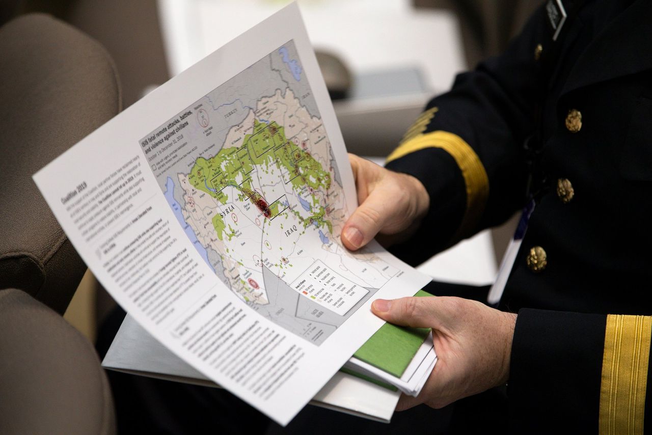 Een Amerikaanse militair toont een kaart van het gebied waar IS actief is in Syrië en Irak.