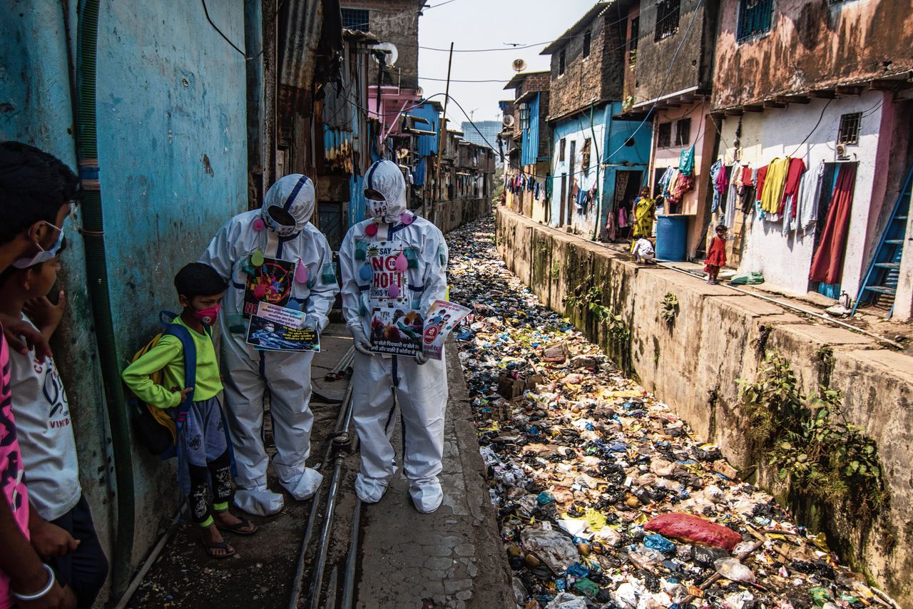 Hulpverleners delen pamfletten uit in Dharavi om bewoners te waarschuwen tegen besmettingsrisico’s.