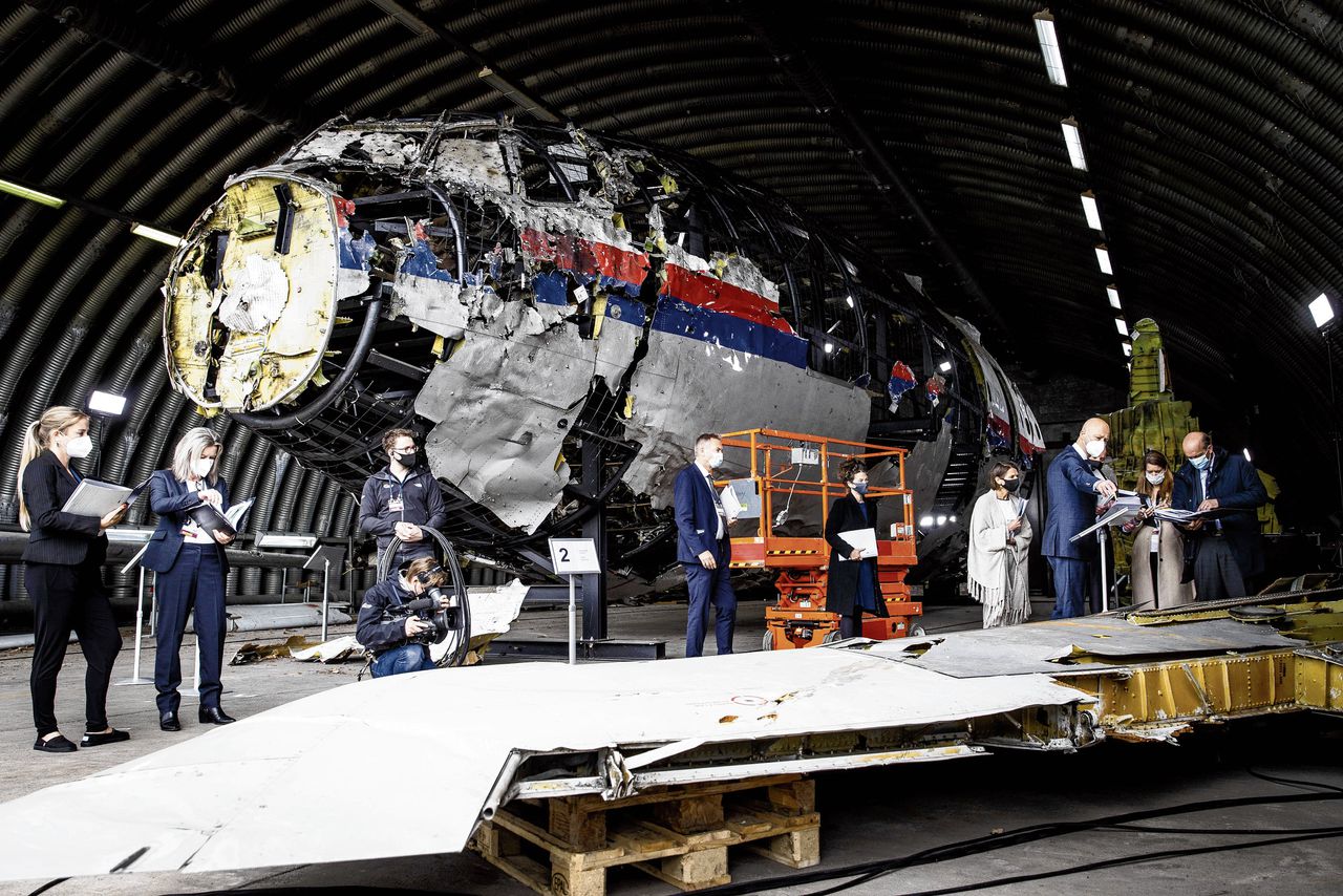 Leden van de rechtbank en advocaten bekijken de reconstructie van het MH17-toestel.