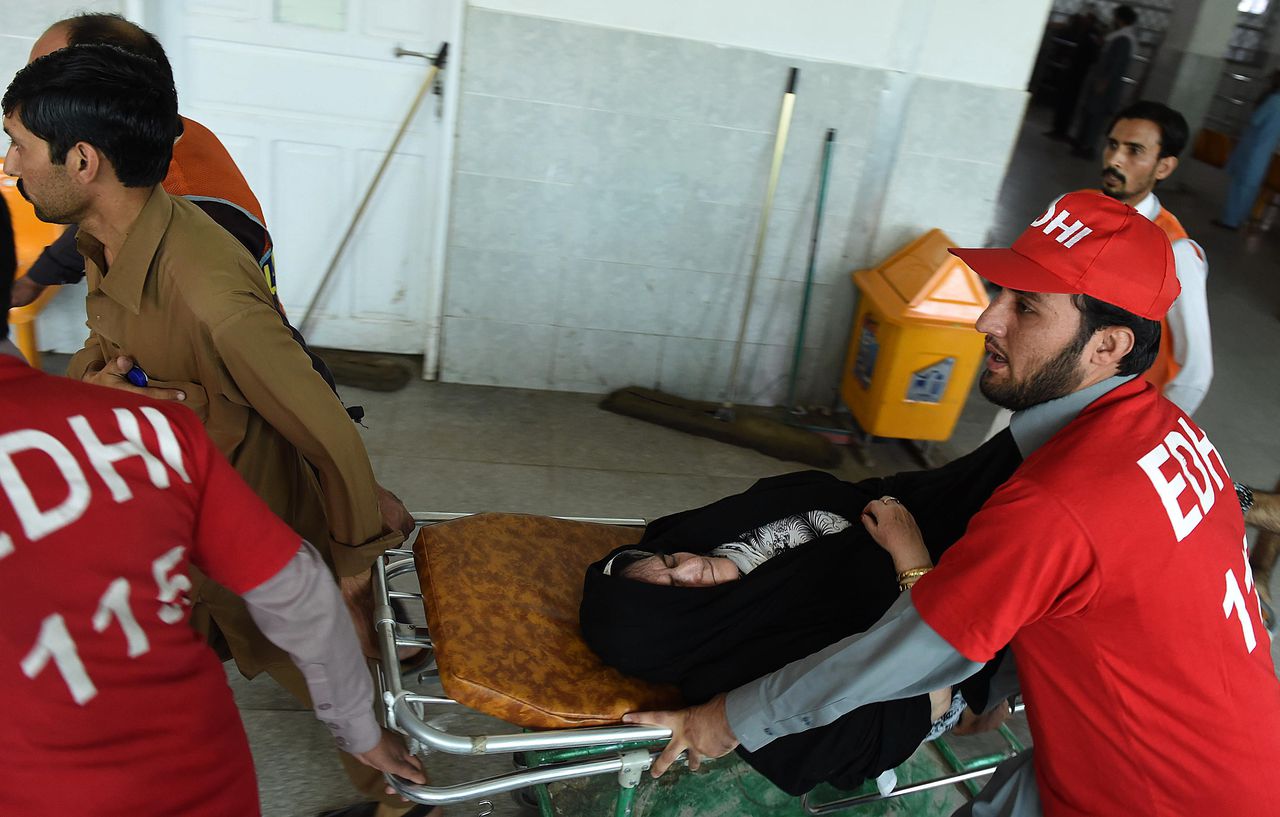 Vrijwillige hulpverleners in Peshawar brengen een gewonde vrouw naar het ziekenhuis.