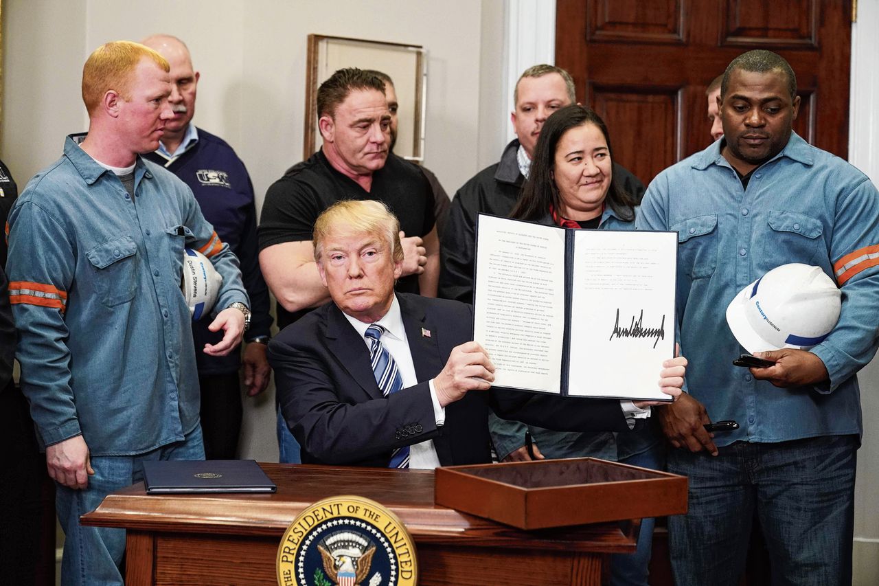De Amerikaanse president Donald Trump laat op 8 maart 2018 zien dat hij net een besluit heeft getekend om importheffingen in te voeren op staal en aluminium.