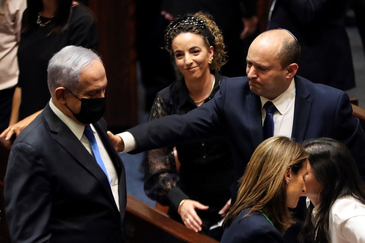 De nieuwe Israëlische premier Naftali Bennett (rechts) gebaart naar zijn voorganger Benjamin Netanyahu, zondagavond in de Knesset in Jeruzalem.
