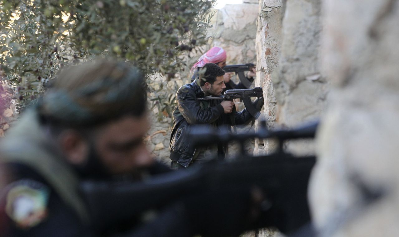 Free Syrian Army fighters aim their weapons during a gunfight with forces loyal to Syrian President Bashar al-Assad near Aleppo's airport December 26, 2012. Syrian rebels are surrounding bases and military airports loyal to President Bashar al-Assad across the northern province of Aleppo, a commander said, but are struggling to counter attacks from jet fighters which can fly even from besieged airfields. REUTERS/Muzaffar Salman (SYRIA - Tags: CIVIL UNREST POLITICS TPX IMAGES OF THE DAY)