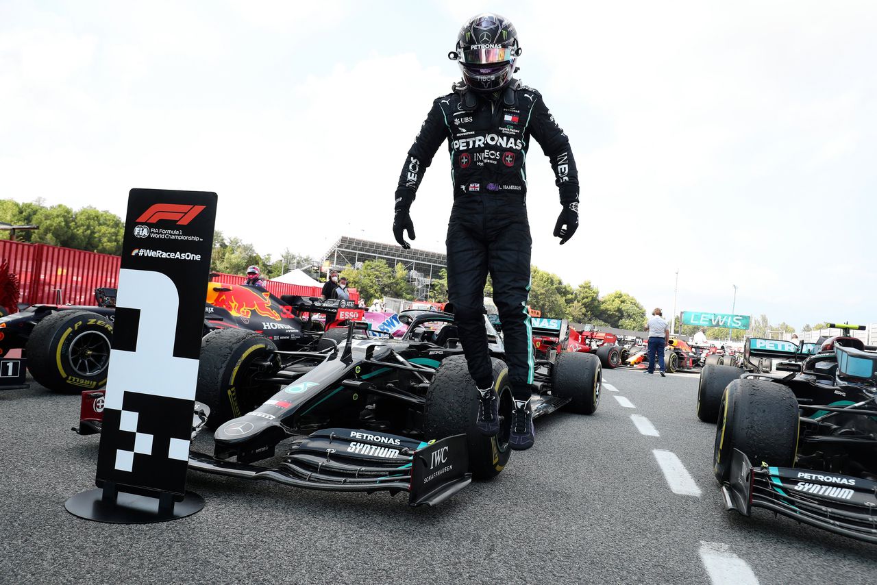 Lewis Hamilton van Mercedes klimt uit zijn wagen na de gewonnen GP op het circuit in Spanje.