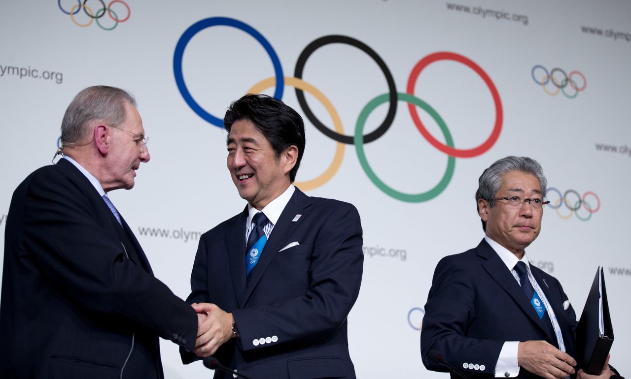 Toenmalig IOC-voorzitter Jacques Rogge met premier Abe (l) en voorzitter van het Olympisch Comité Takeda in 2013, na de toewijzing van de Olympische Spelen.
