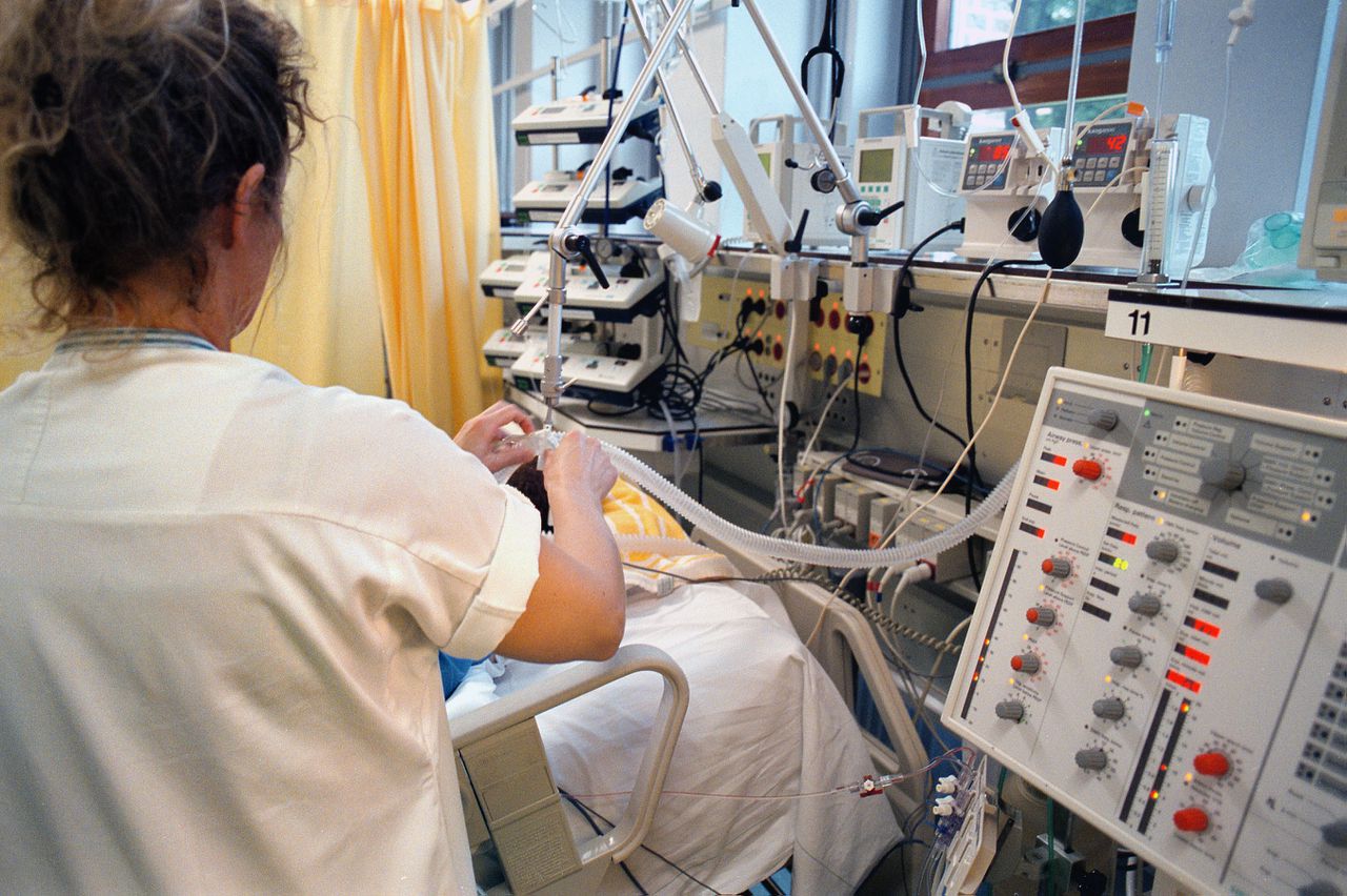 Nederland, Nijmegen, 1-11-2004 Intensive Care verpleegkundige verzorgt patiënt en controleert de apparatuur. Problemen gezondheidszorg, beddentekort,wachtlijsten. Foto: Flip Franssen