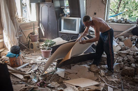 Een man staat in zijn appartement, verwoest door gevechten tussen pro-Russische militanten en Oekraïense troepen in Slavjansk.