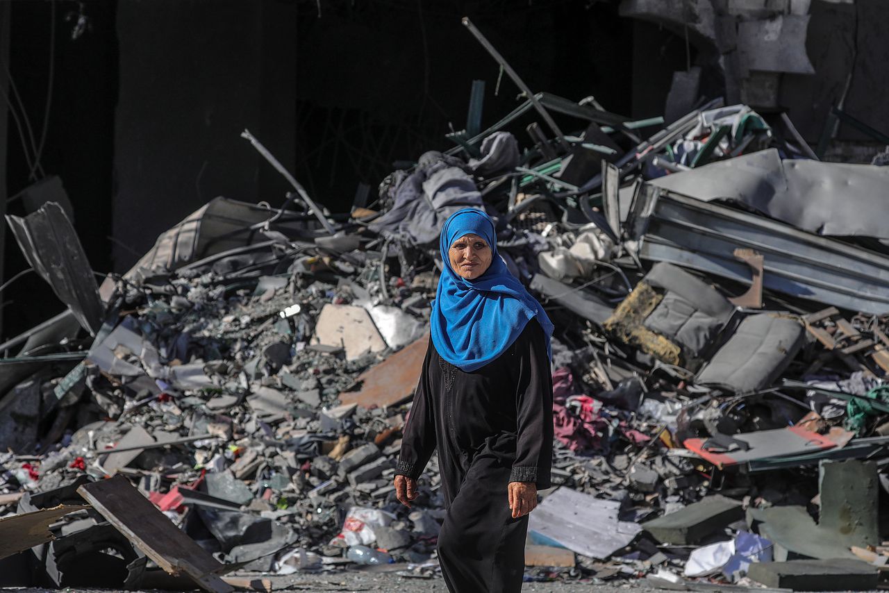 Een Palestijnse vrouw loopt langs een gebouw dat verwoest is door een Israëlisch bombardement, 13 mei 2021.