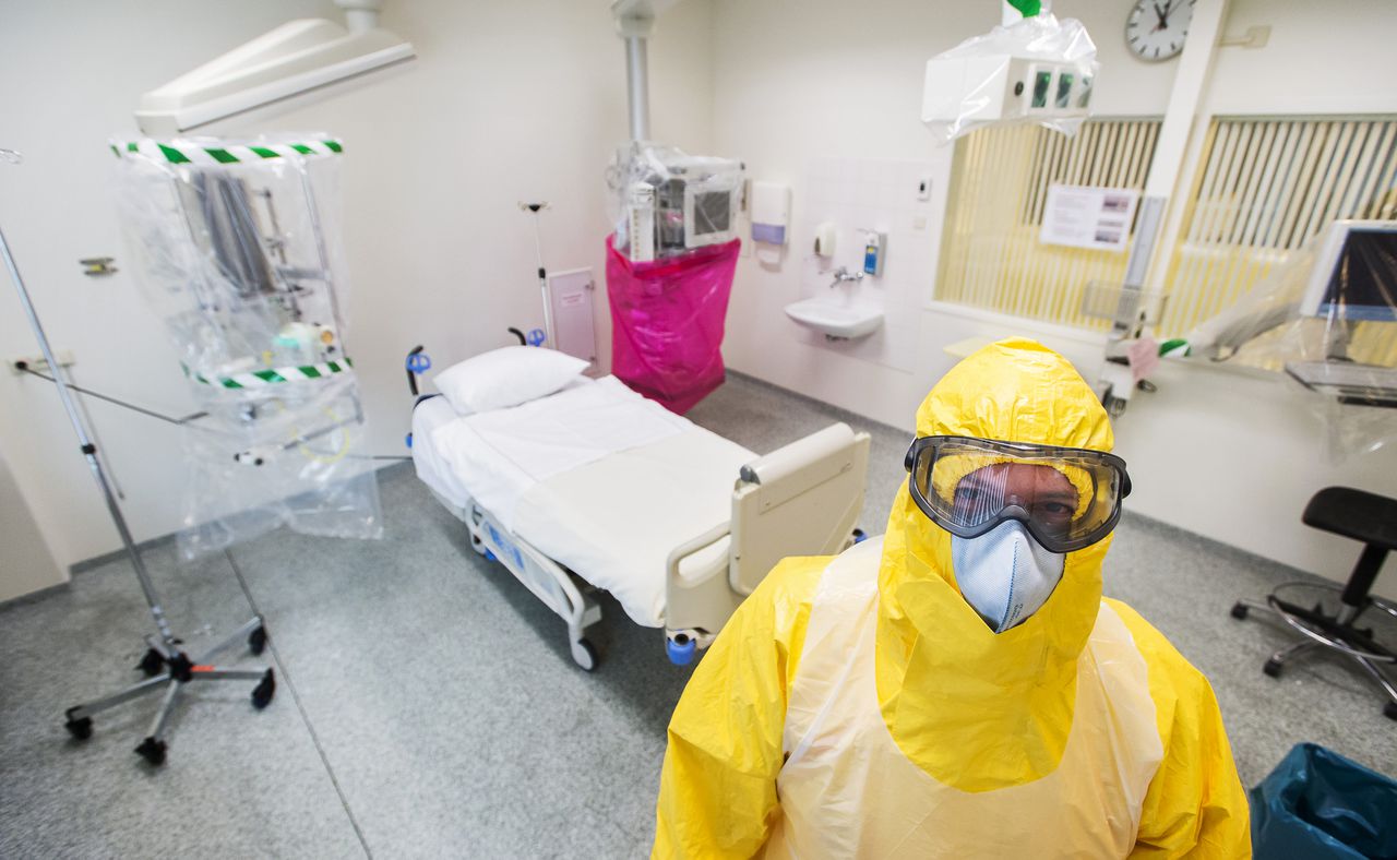 Een arts in speciale kleding in een geïsoleerde kamer voor de behandeling van een patiënt met het ebola-virus in het AMC.