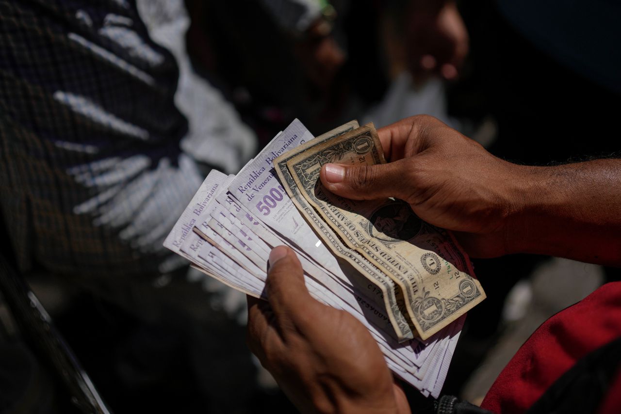Een man telt in de Venezolaanse hoofdstad Caracas bolivars en Amerikaanse dollars. Venezuela scoort erg slecht op de corruptie-index.