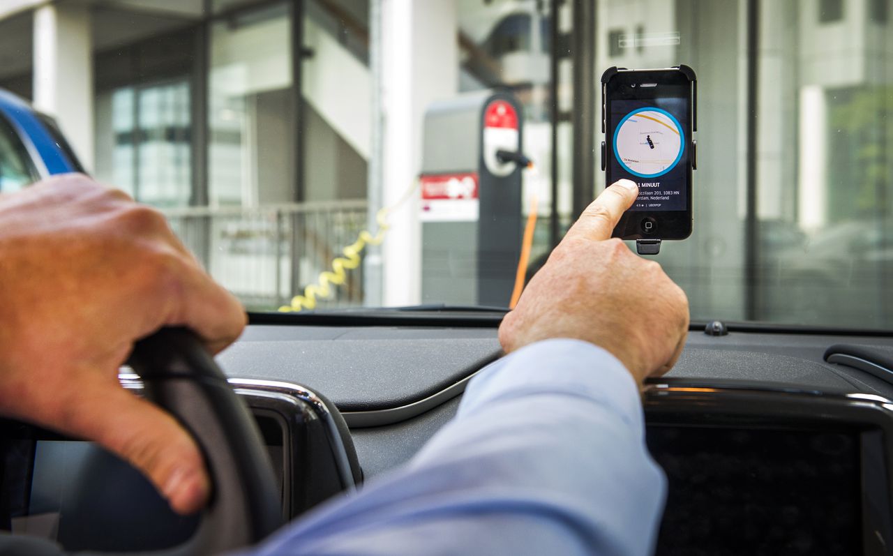 Een chauffeur van Uber in Amsterdam accepteert een aanvraag voor een rit van een klant.