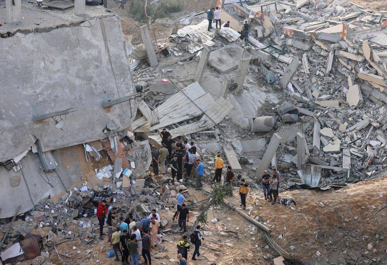Inwoners van Gaza inspecteren de schade na een Israëlische luchtaanval donderdagochtend.