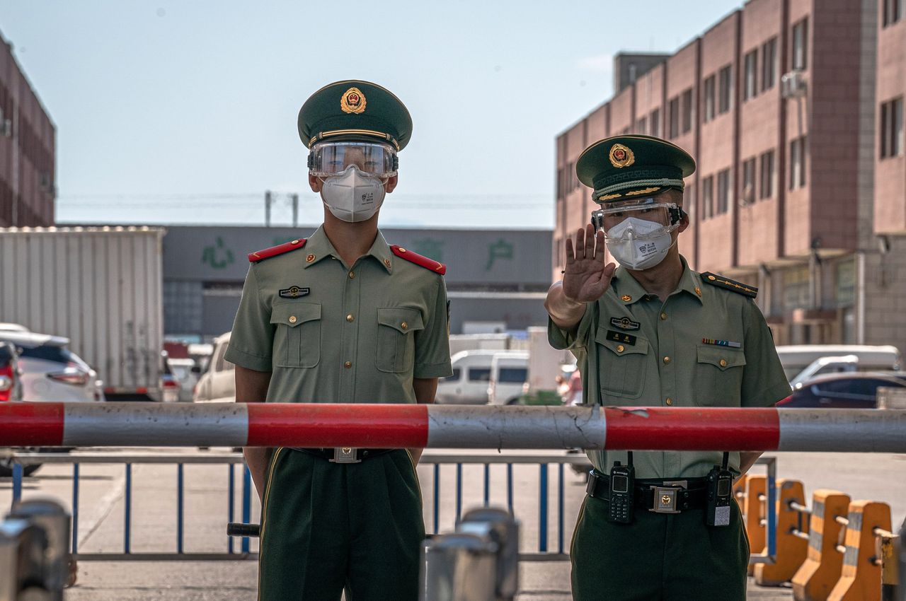De Xinfadi-markt in Beijing is sinds zaterdag gesloten en wordt afgeschermd door politie met beschermende maskers. Nadat nieuwe coronabesmettingen werden geconstateerd is het omliggende Fengtai-district afgegrendeld. ROMAN PILIPEY/EPA