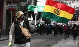 Een inheemse Boliviaanse man zwaait maandag met een vlag tijdens een demonstratie in de hoofdstad La Paz uit onvrede over de president. 