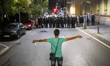 Een demonstrant staat voor de oproerpolitie tijdens een antiregeringsdemonstratie in Valjevo, in het westen van Servië.