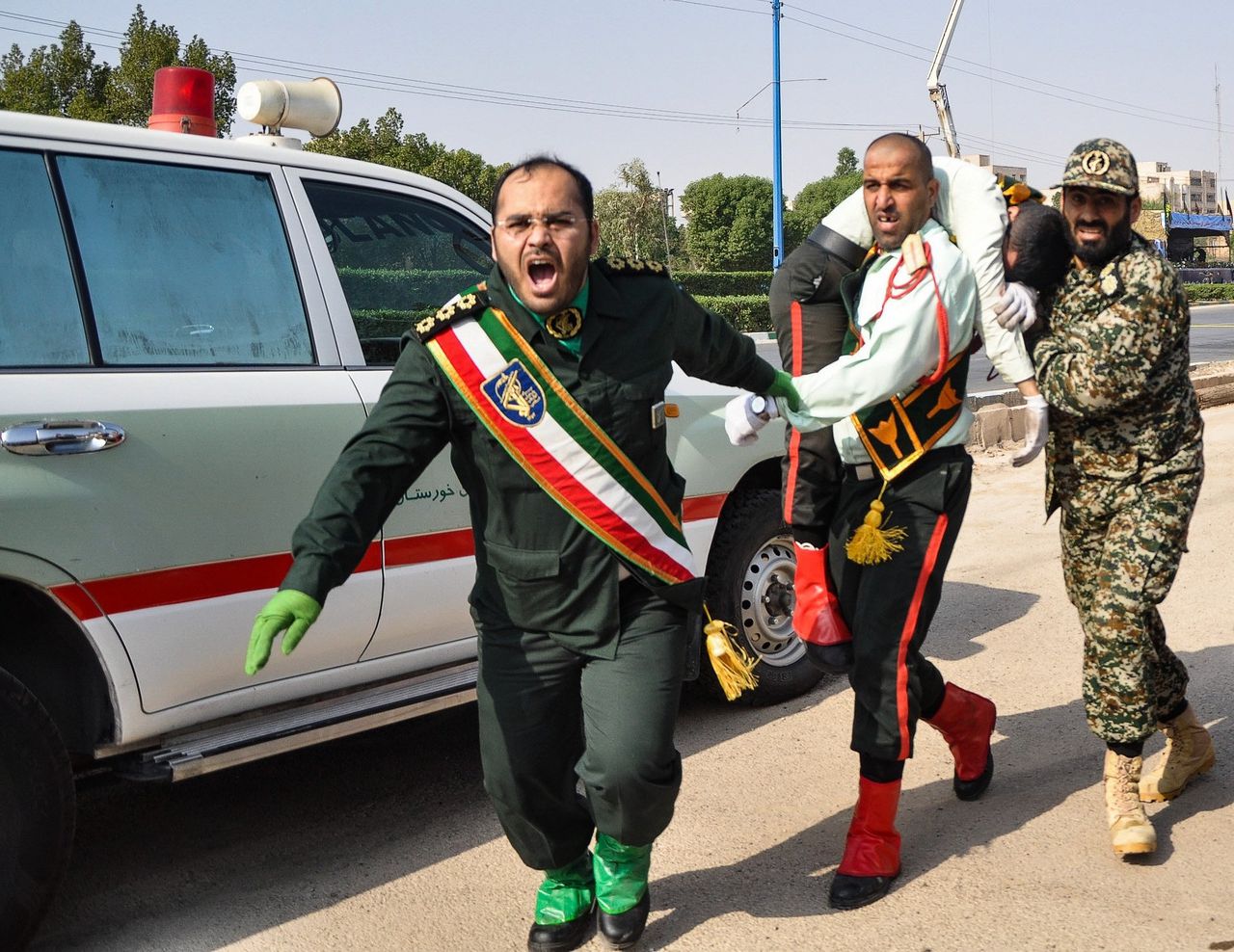 Iraanse soldaten dragen een gewonde weg na de aansag in Ahwaz.