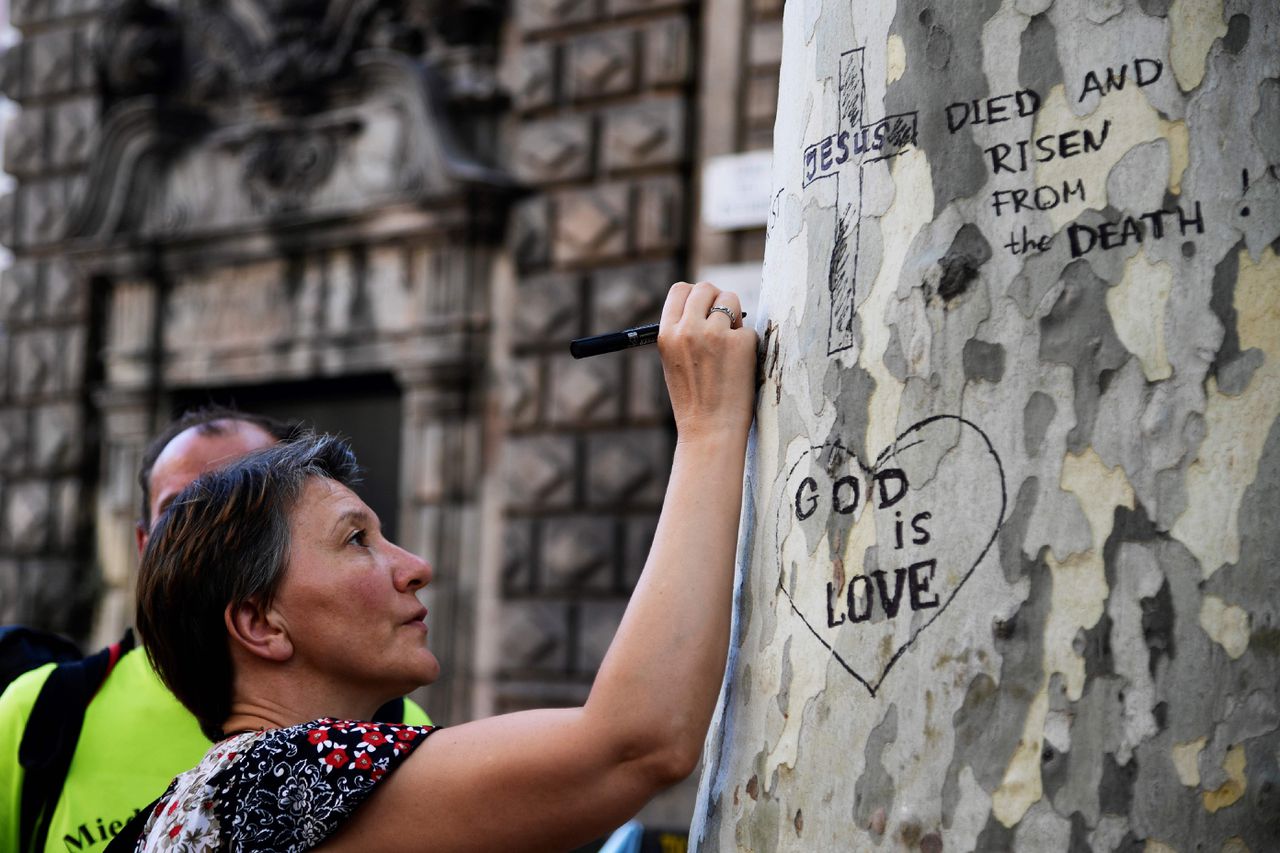 Een dag na de aanslag schrijft een boodschap op een boom bij het Plaza de Catalunya.