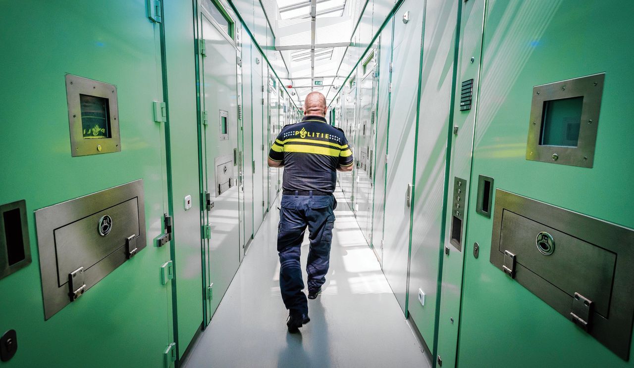 Archiefbeeld van een agent die in het cellencomplex van een politiebureau in Rotterdam loopt.