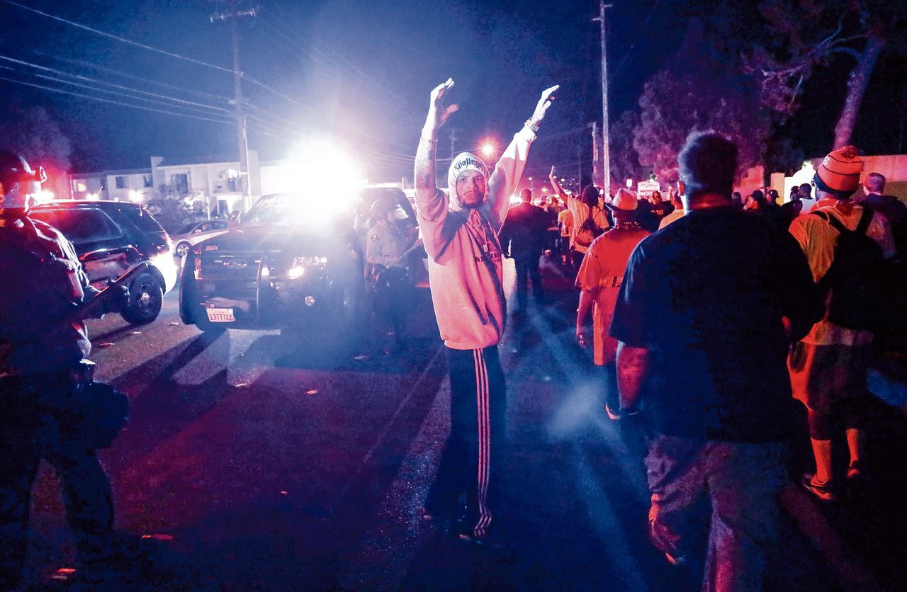 Een protestleider stuurt betogers weg bij oproerpolitie tijdens een demonstratie naar aanleiding van de dood van Alfred Olango, die werd doodgeschoten door de politie in El Cajon, Californië, in september.