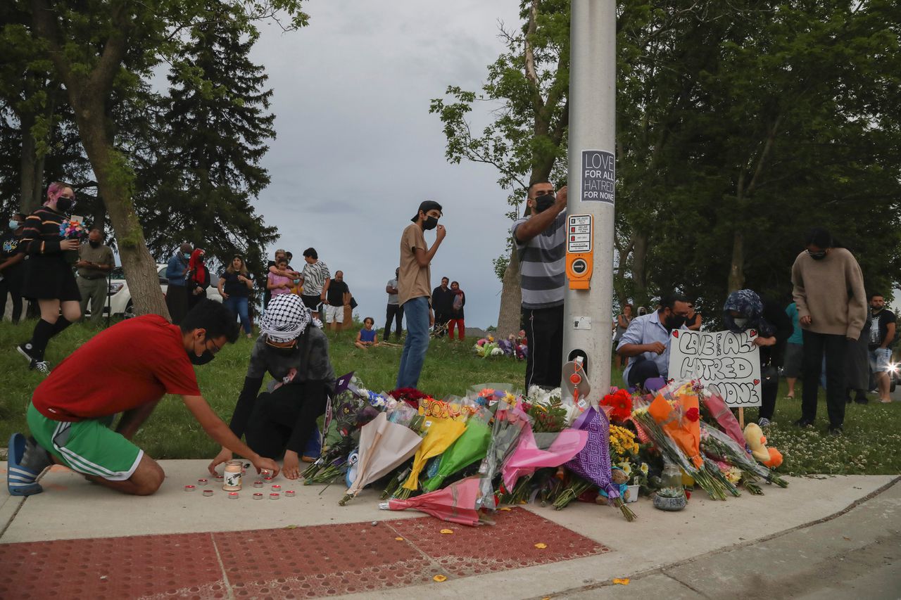 Mensen leggen bloemen bij de plek in London, in de Canadese provincie Ontario, waar zondag een moslimfamilie opzettelijk werd aangereden door een automobilist, waarbij vier mensen omkwamen.