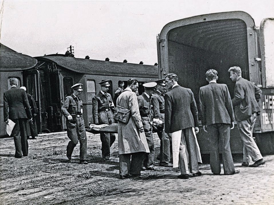 Het Nederlandse Rode Kruis evacueerde in de Tweede Wereldoorlog ook zieken. Hier wordt een psychiatrische patiënt vanaf een onbekend station verder vervoerd .