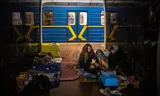 Een vrouw schuilt met haar kat voor de luchtaanvallen in een metrostation in Kyiv, in maart 2022. 