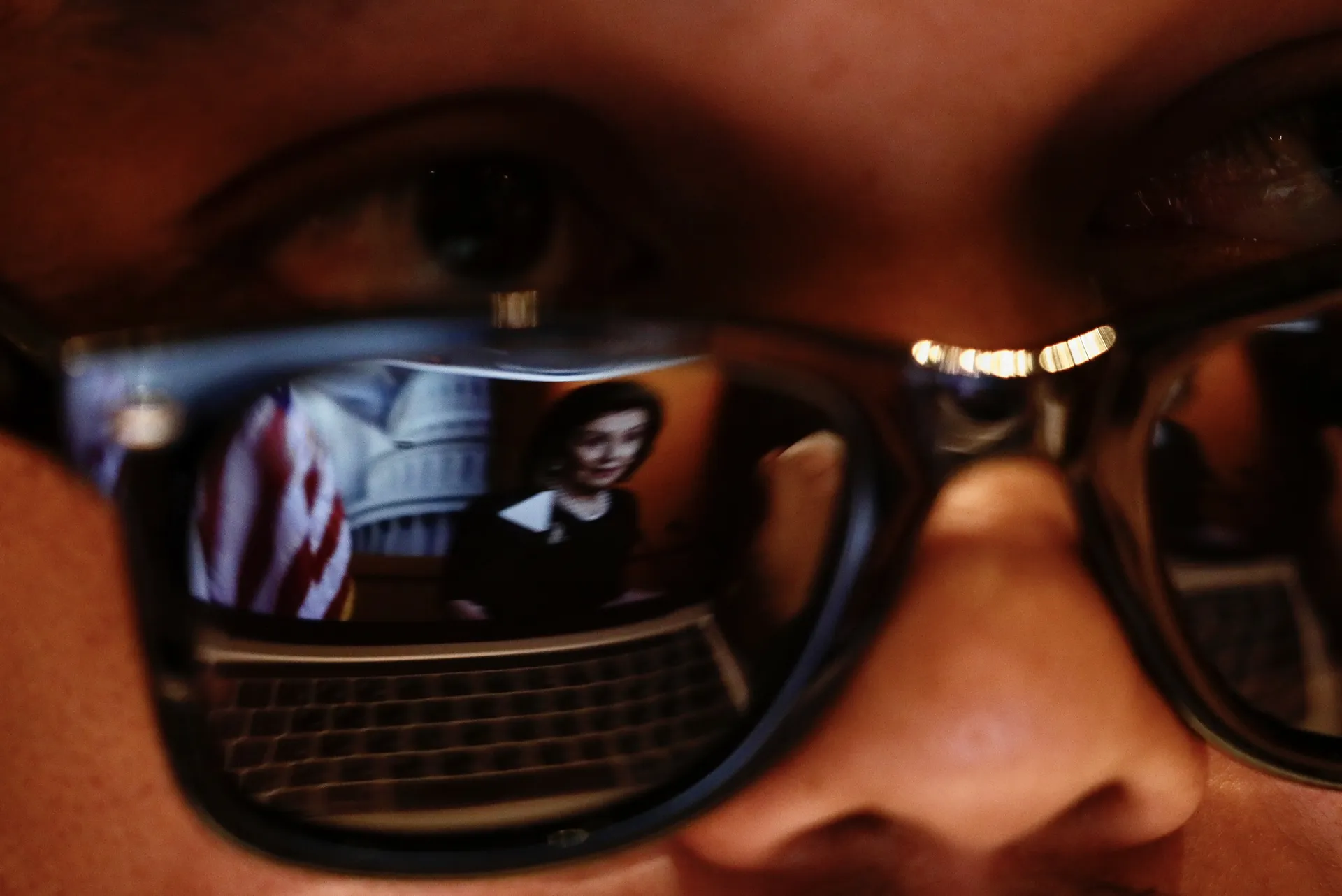 Foto van van zonnebril met reflectie van beeldscherm met beeld van Nancy Pelosi