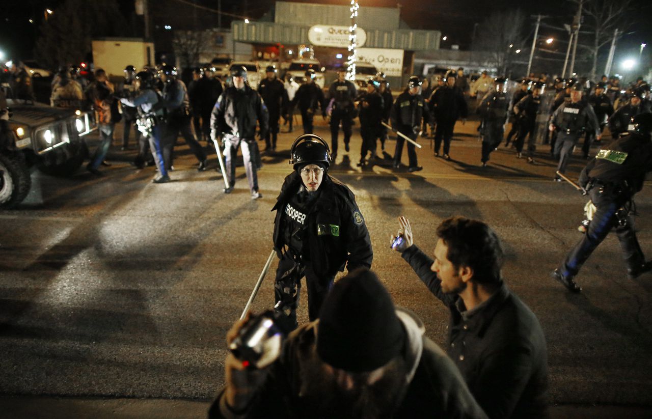 Politieagenten proberen de mensenmenigte in Ferguson in toom te houden na een eerder besluit om Wilson niet te vervolgen.